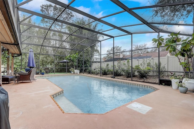 view of pool with glass enclosure, a patio, fence, and a fenced in pool