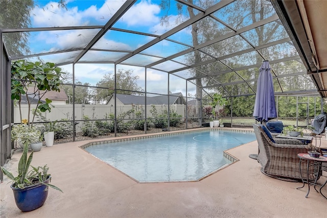 view of pool featuring glass enclosure, a patio, a fenced backyard, and a fenced in pool