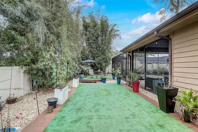 view of yard with a lanai, a wooden deck, and fence