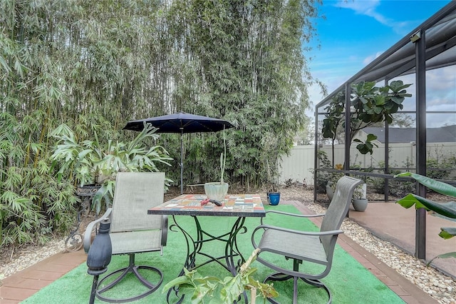 view of patio / terrace with a lanai and fence