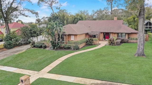 view of front of property featuring roof with shingles, a front lawn, and a chimney