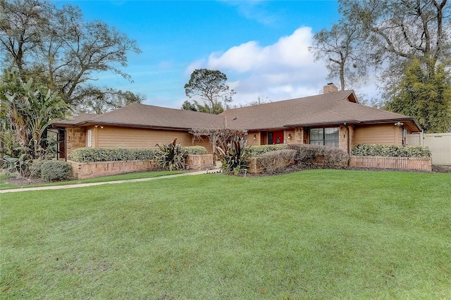 ranch-style house featuring a chimney and a front yard