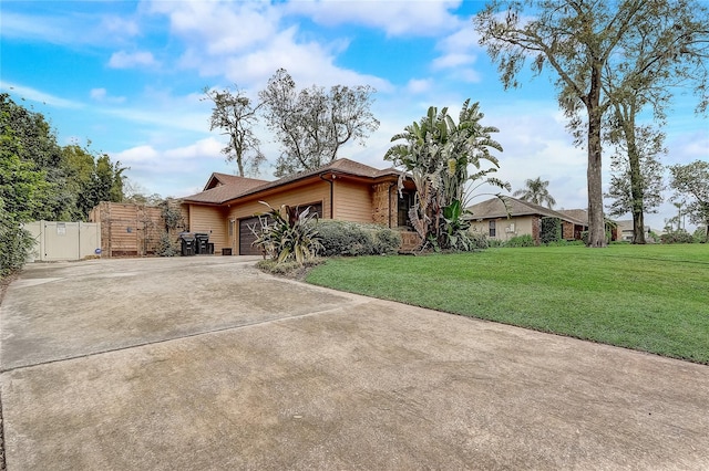 view of front of property with driveway, an attached garage, fence, and a front lawn