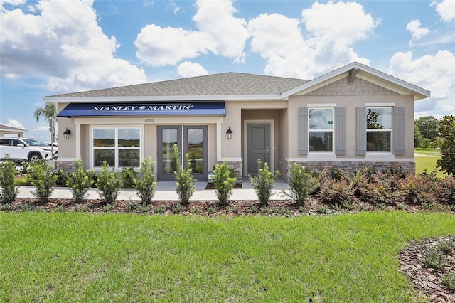 view of front of house with stone siding, a front lawn, and stucco siding