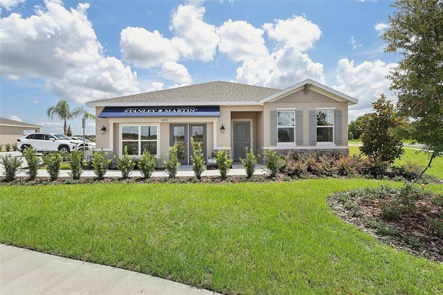 view of front of home featuring a front yard, stone siding, and stucco siding