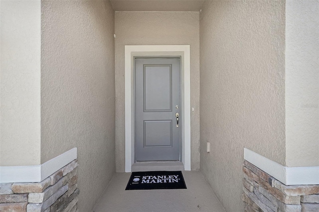 view of exterior entry with stucco siding