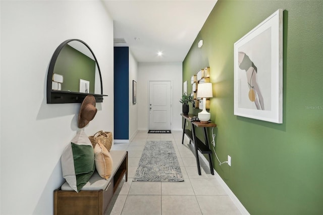 hallway with baseboards and light tile patterned floors