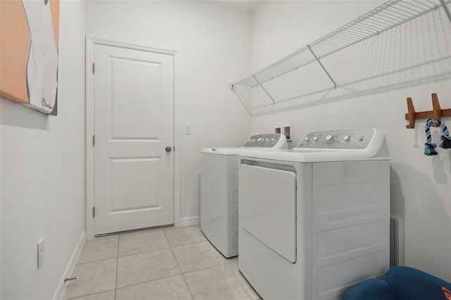 clothes washing area with laundry area, light tile patterned floors, baseboards, and independent washer and dryer