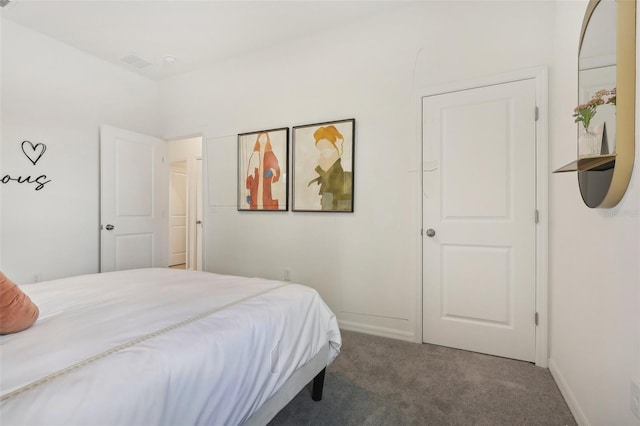 bedroom featuring dark carpet and baseboards