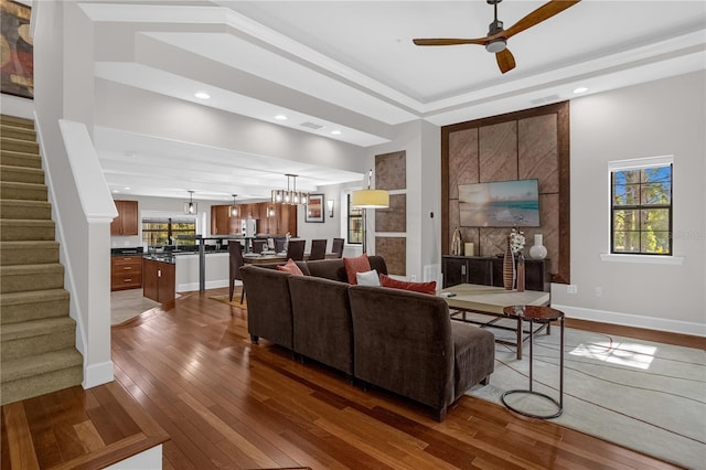 living room featuring plenty of natural light, stairs, baseboards, and dark wood finished floors