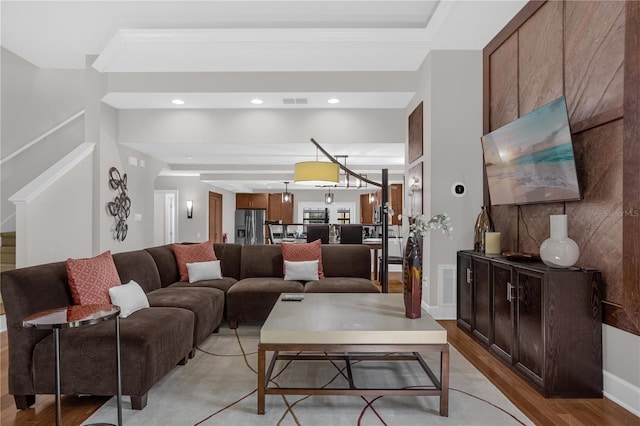 living room featuring recessed lighting, visible vents, light wood-style floors, baseboards, and stairs