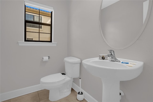 bathroom with tile patterned flooring, baseboards, and toilet