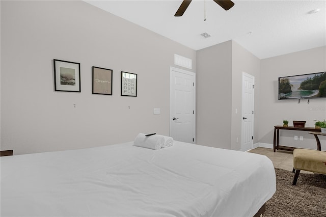 bedroom featuring light tile patterned floors, visible vents, baseboards, and a ceiling fan