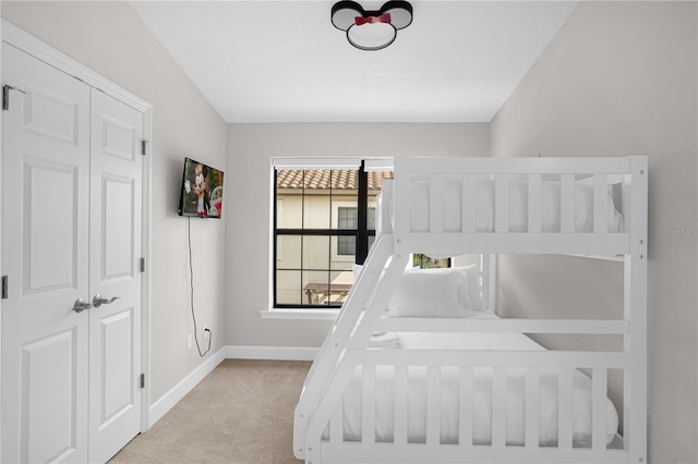 bedroom with baseboards and light colored carpet