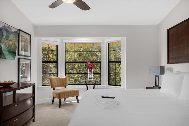 bedroom featuring ceiling fan, baseboards, and light colored carpet