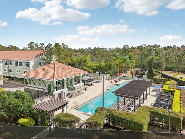 community pool with a patio area, fence, and a pergola