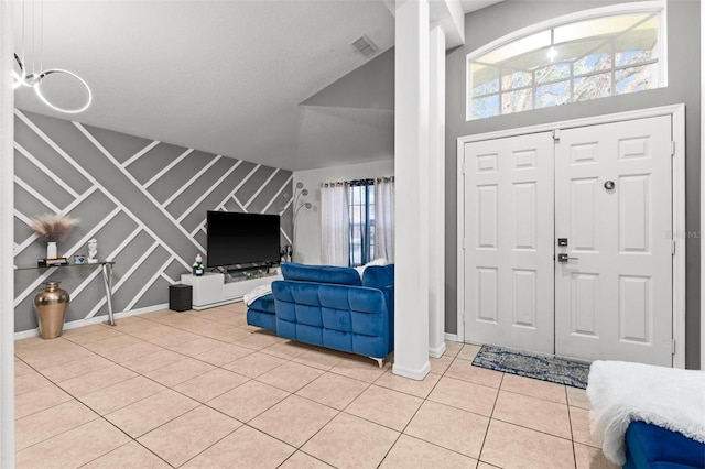 entrance foyer with light tile patterned floors, baseboards, stairway, and visible vents