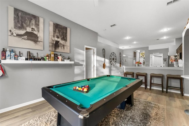 recreation room with visible vents, baseboards, and wood finished floors