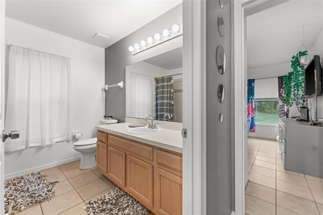 full bathroom with a textured ceiling, tile patterned flooring, toilet, vanity, and baseboards