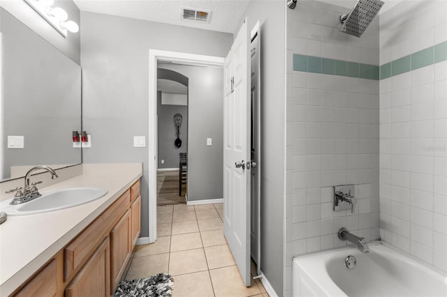 full bathroom with visible vents, tile patterned floors, tub / shower combination, a textured ceiling, and vanity