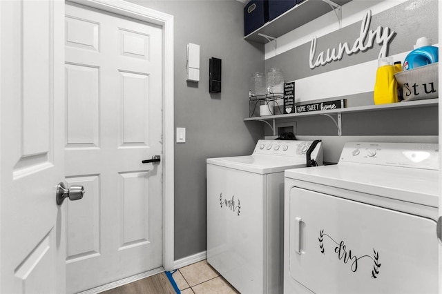 laundry room with light tile patterned floors, laundry area, washer and clothes dryer, and baseboards