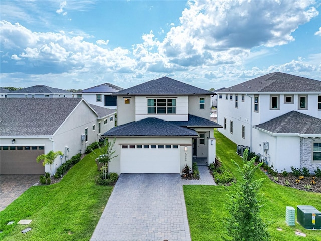 view of front of property featuring a garage, a residential view, decorative driveway, and a front lawn