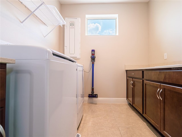 laundry area with light tile patterned floors, independent washer and dryer, cabinet space, and baseboards