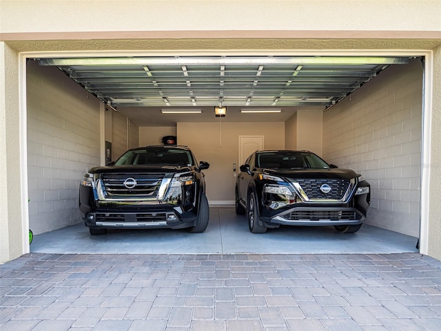 garage with a garage door opener and decorative driveway