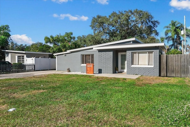 view of front of home featuring fence and a front lawn