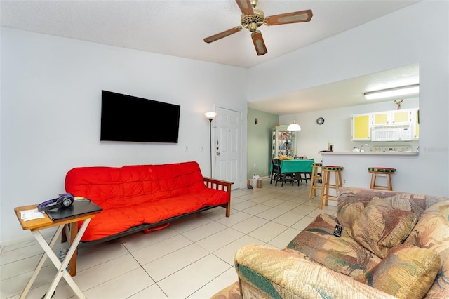 living area with light tile patterned floors, vaulted ceiling, and a ceiling fan