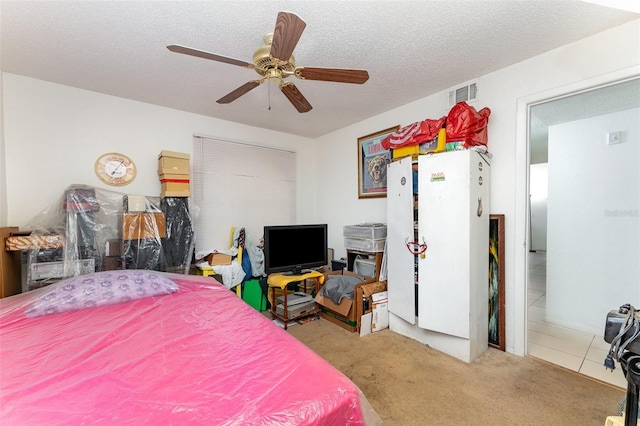 carpeted bedroom with a ceiling fan, visible vents, and a textured ceiling