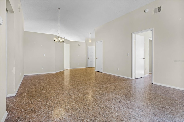 empty room featuring visible vents, vaulted ceiling, baseboards, and an inviting chandelier