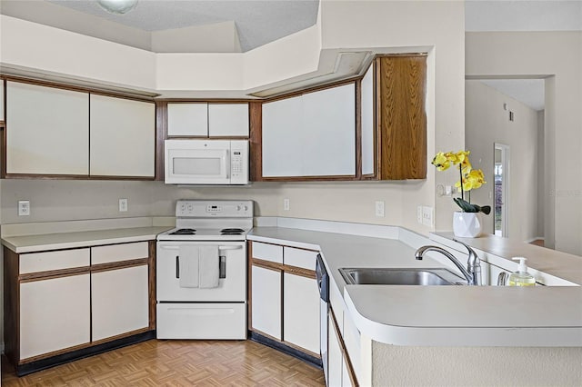 kitchen featuring white appliances, light countertops, a textured ceiling, and white cabinetry