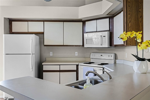 kitchen featuring light countertops, white appliances, white cabinets, and a sink