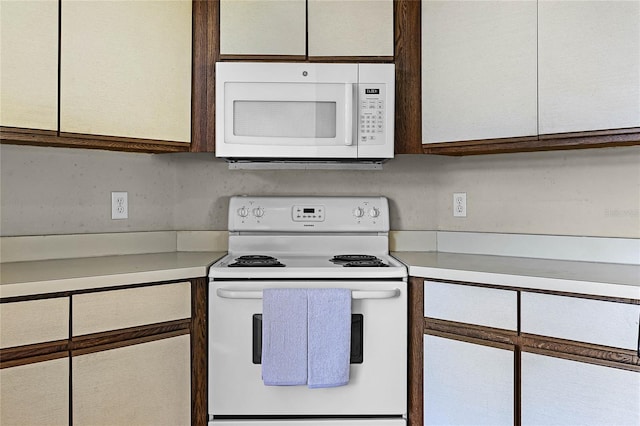 kitchen with white cabinets, white appliances, and light countertops