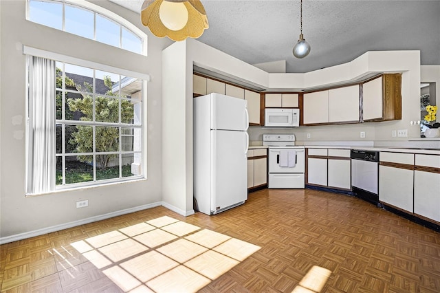 kitchen featuring a textured ceiling, light countertops, white appliances, and white cabinetry