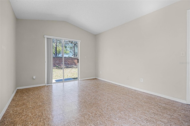 spare room featuring baseboards, vaulted ceiling, and a textured ceiling