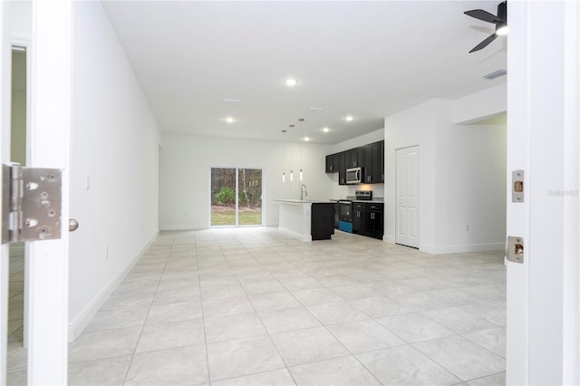 unfurnished living room with visible vents, a sink, recessed lighting, baseboards, and ceiling fan