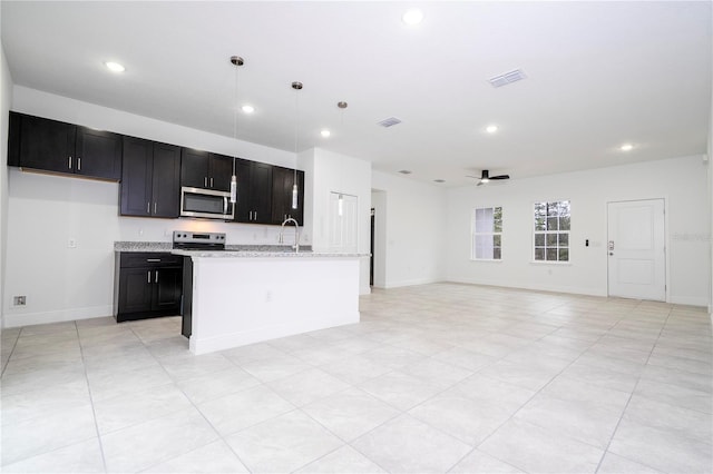 kitchen featuring a ceiling fan, recessed lighting, a sink, appliances with stainless steel finishes, and open floor plan