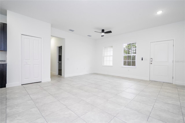unfurnished room with baseboards, visible vents, and ceiling fan