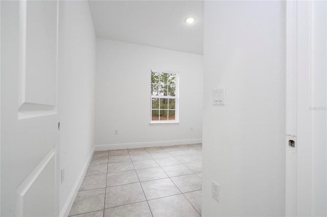 unfurnished room with light tile patterned flooring and baseboards