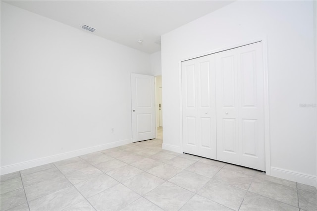 unfurnished bedroom featuring visible vents, baseboards, and a closet