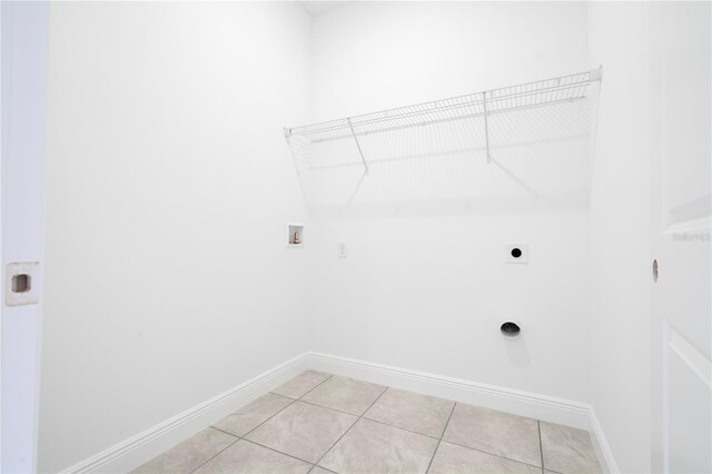 clothes washing area featuring baseboards, washer hookup, light tile patterned floors, laundry area, and hookup for an electric dryer