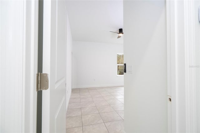 hallway featuring light tile patterned floors and baseboards