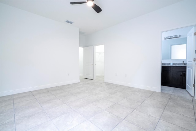 unfurnished bedroom with baseboards, visible vents, ensuite bath, a spacious closet, and a closet
