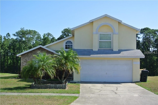 traditional home with brick siding, stucco siding, a front yard, a garage, and driveway