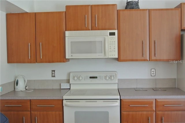 kitchen featuring light countertops, white appliances, and modern cabinets