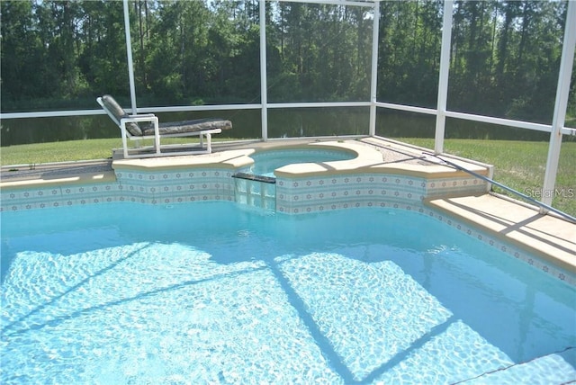 outdoor pool featuring a lanai and an in ground hot tub