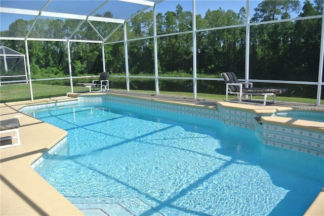 outdoor pool with glass enclosure, a hot tub, and a patio