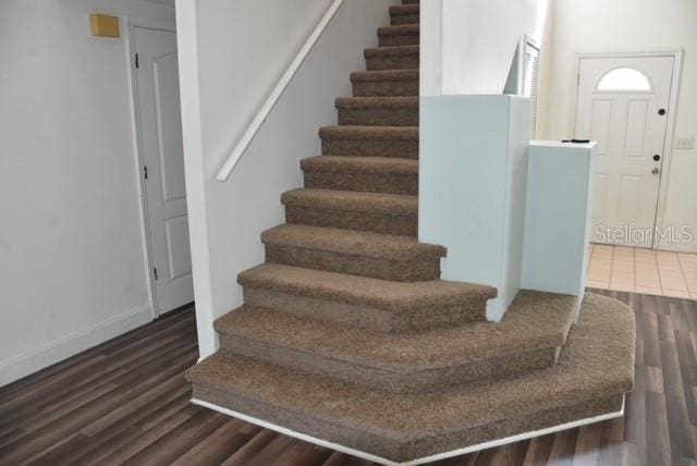 stairs featuring baseboards and wood finished floors